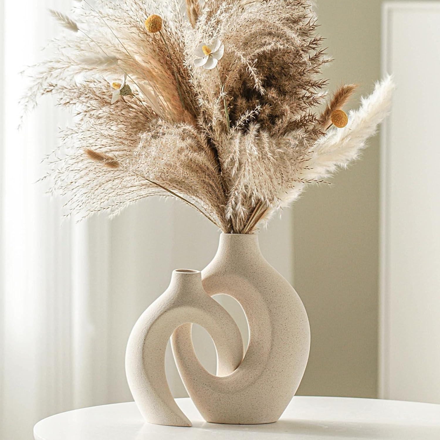 A set of two aesthetic ceramic vases with organic flowing shapes styled on a wooden shelf