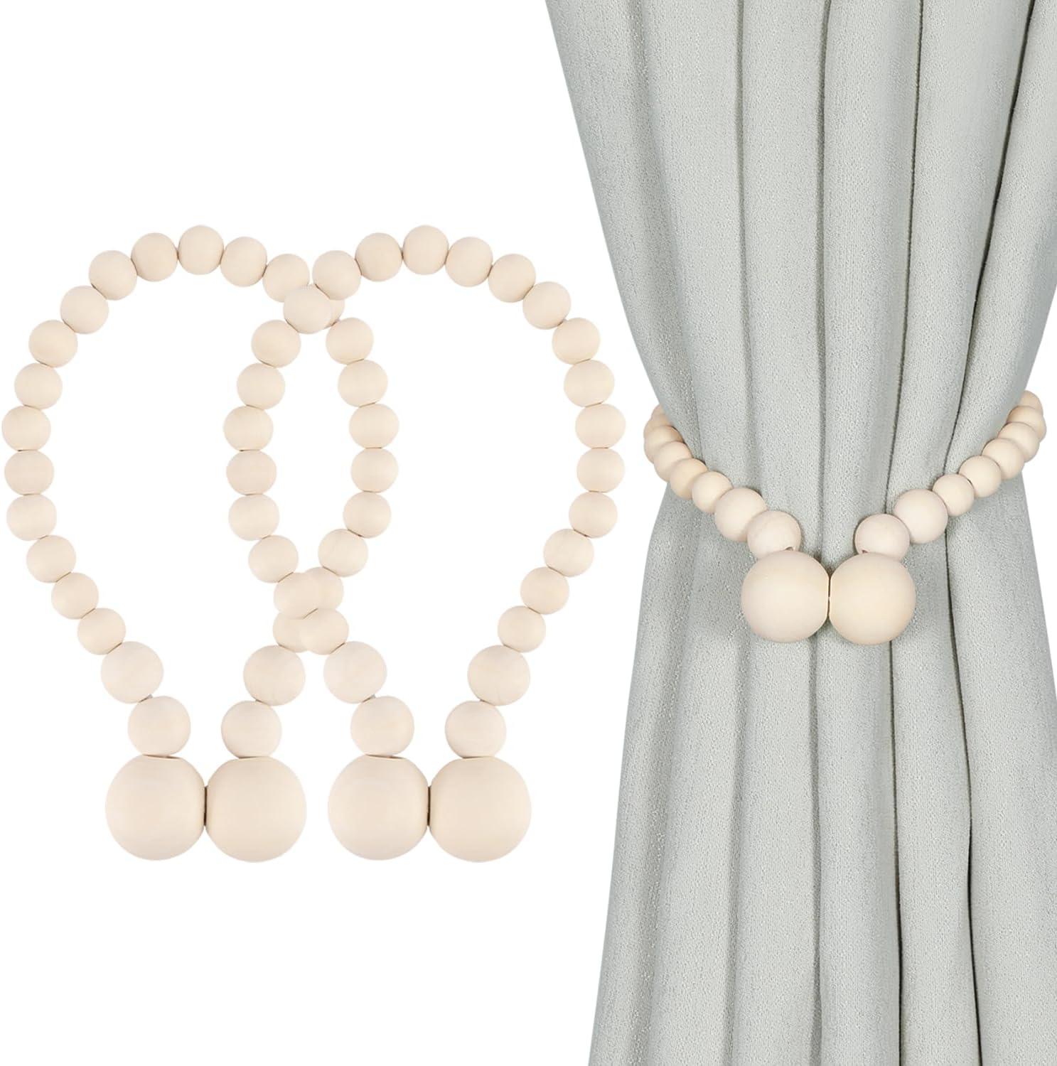 Cream wood bead magnetic curtain tieback wrapped around soft gray curtains, creating neutral boho farmhouse window decor with a calm nursery or bedroom mood.