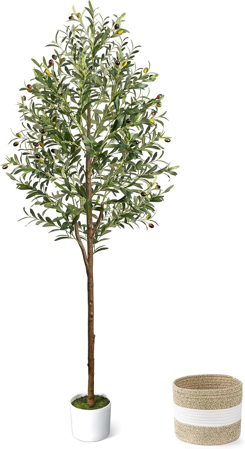 Tall faux olive tree with realistic green leaves and olives, styled with a white planter and woven basket for cozy neutral living room decor.