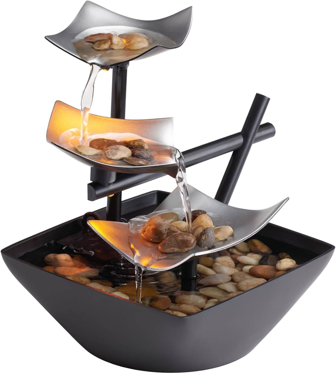 Indoor tabletop water fountain with black tiers, flowing water, river rocks, and warm glow styled for calm minimalist home decor.
